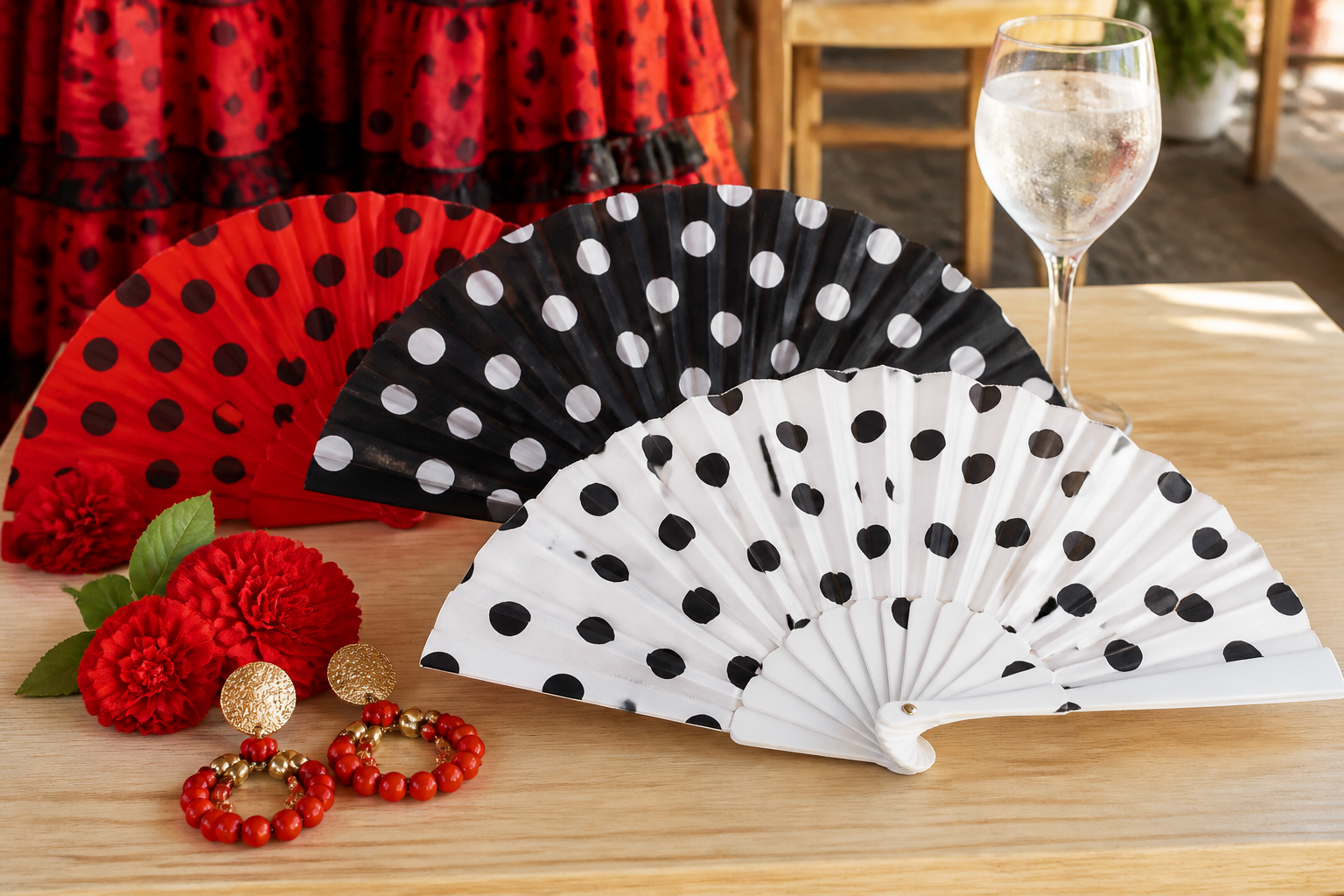 Abanicos rojos, negros y blancos de lunares junto a flores y pendientes de feria