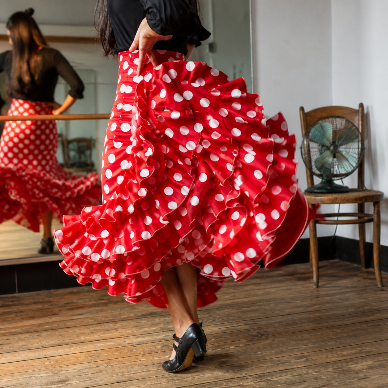 Falda flamenca roja de lunares blancos con volantes en movimiento en un estudio de baile